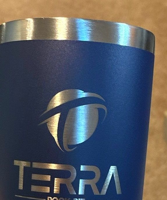 A custom logo laser engraved on a navy tumbler.